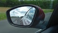 Car rearview mirror modern vehicle in road view and clouds Royalty Free Stock Photo