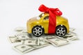 Car with a red bow and dollars on a white background. Car as a gift. Buy a car. Royalty Free Stock Photo