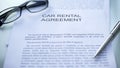 Car rental agreement lying on table, pen and eyeglasses on official document Royalty Free Stock Photo