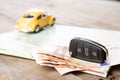 Car rental concept - car key and money on the map Royalty Free Stock Photo