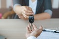 Close up view Hand of agent giving car key to customer after signed rental contract form Royalty Free Stock Photo