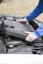 Car repair shop. The mechanic put on a plastic engine cover.