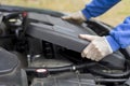 Car repair shop. The mechanic put on a plastic engine cover.