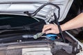 A car repairman unscrews parts with a wrench with a green handle in the engine compartment in a vehicle workshop Royalty Free Stock Photo