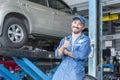 Car repairs. Happy auto mechanic man or smith at car workshop. A car mechanic showing his thumb up