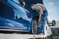 Car Repossession Worker Securing Vehicle on His Towing Truck Royalty Free Stock Photo