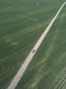 Car rides on the road, around green fields. Royalty Free Stock Photo