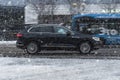 Car rides through a snowstorm. VW Touareg Third generation (CR) in the traffic of the city