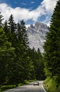 Car on a road in Dolomite Mountains with Forested Slopes in Italy Royalty Free Stock Photo