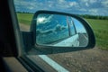 Car on the road with motion blur background and rear view mirror. Travel concept. Cloudy sky Royalty Free Stock Photo