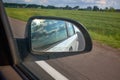 Car on the road with motion blur background and rear view mirror. Travel concept. Cloudy sky Royalty Free Stock Photo