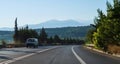 Car on the road and mountains behind it in Crete, Greece Royalty Free Stock Photo