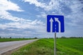 Car road sign `The end of the additional lane on the rise or runaway strip` against a blue sky