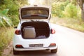 Car on the road with a suitcase in the trunk, travel concept. White cars parked on the roadside, with natural Royalty Free Stock Photo