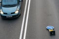 A car on the roadway is viewed from above from a quadrocopter. Various road signs on the roadway. Road repairs. Double marking