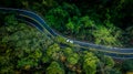Car in rural road in deep rain forest with green tree forest, Aerial view car in the forest