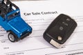 Car sale contract, blue toy car and black key. Sales, purchases of vehicle Royalty Free Stock Photo