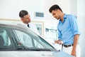 Car Sales Consultant Showing a New Car to a Potential Buyer in S Royalty Free Stock Photo