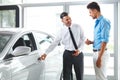 Car Sales Consultant Showing a New Car to a Potential Buyer in S