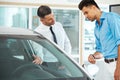 Car Sales Consultant Showing a New Car to a Potential Buyer in S Royalty Free Stock Photo