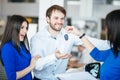 Car salesgirl giving the key of the new car to the attractive couple owners. Royalty Free Stock Photo