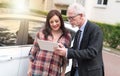 Car salesman giving explanations on tablet to young woman, light effect Royalty Free Stock Photo