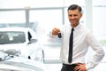 Car Salesman Giving Key of New Car at Showroom