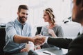 Car salesman giving the key of the new car to the young attractive owners Royalty Free Stock Photo