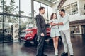 Its good choice!Car salesman is giving the key of the new car to the young attractive owners Royalty Free Stock Photo