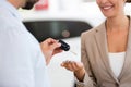 Car salesman handing car keys to woman