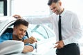 Car Salesman Handing over new Car Key to Customer at Showroom