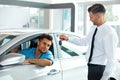 Car Salesman Handing over new Car Key to Customer at Showroom Royalty Free Stock Photo