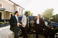 Car salon, sale and rent concept. African and Caucasian men in business wear buying the car. Elegant woman car Royalty Free Stock Photo