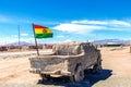 Salty Jeep sculpture and Bolivian Flag in salt flat Salar de Uyuni, Bolivia Royalty Free Stock Photo