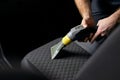 Car seat vacuum, detailing and cleaning interior seats luxury modern cars. Close-up photo of hands with vacuum cleaner Royalty Free Stock Photo