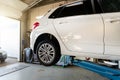 Car service center. Bottom behind pov vehicle raised on lift technician worker perform diagnosticas and inspection at