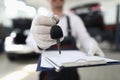 Car service employee holds keys in hand and clipboard