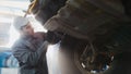 Car service - a mechanic checks the wheel of SUV, wide angle, backlight Royalty Free Stock Photo