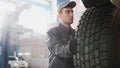 Car service - a mechanic checks the wheel of SUV, wide angle Royalty Free Stock Photo