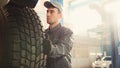 Car service - a mechanic checks the wheel of SUV, wide angle Royalty Free Stock Photo