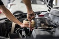 Car service, mechanic tightening nuts of engine cover at the maintenance garage. Auto service, close up.