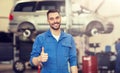 Happy auto mechanic man or smith at car workshop Royalty Free Stock Photo
