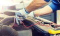 Auto mechanic man with multimeter testing battery Royalty Free Stock Photo