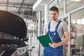 Car service, repair, maintenance and people concept - auto mechanic man or smith with clipboard at workshop Royalty Free Stock Photo