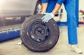 Mechanic with wheel tire at car workshop Royalty Free Stock Photo