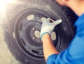 Mechanic with wheel tire at car workshop Royalty Free Stock Photo