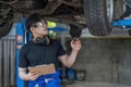 car service, repair, maintenance and people concept - happy smiling auto mechanic man or smith with clipboard at Royalty Free Stock Photo