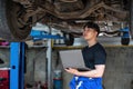 car service, repair, maintenance and people concept - happy smiling auto mechanic man or smith with clipboard at Royalty Free Stock Photo