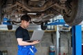 car service, repair, maintenance and people concept - happy smiling auto mechanic man or smith with clipboard at Royalty Free Stock Photo