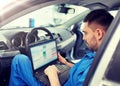 Mechanic man with laptop making car diagnostic Royalty Free Stock Photo